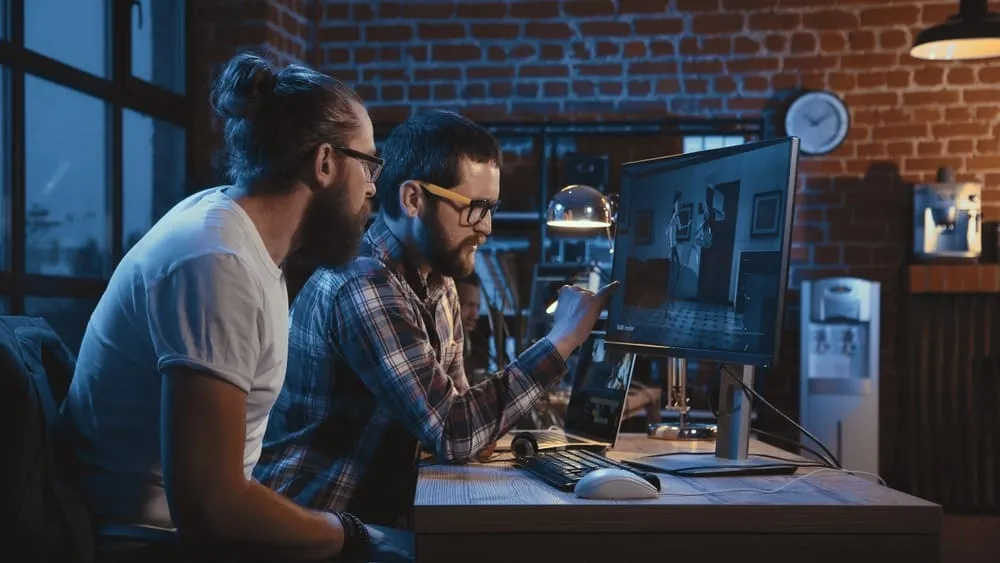 Animators sitting at desks in the animation industry, focused on their work displayed on computer monitors.
