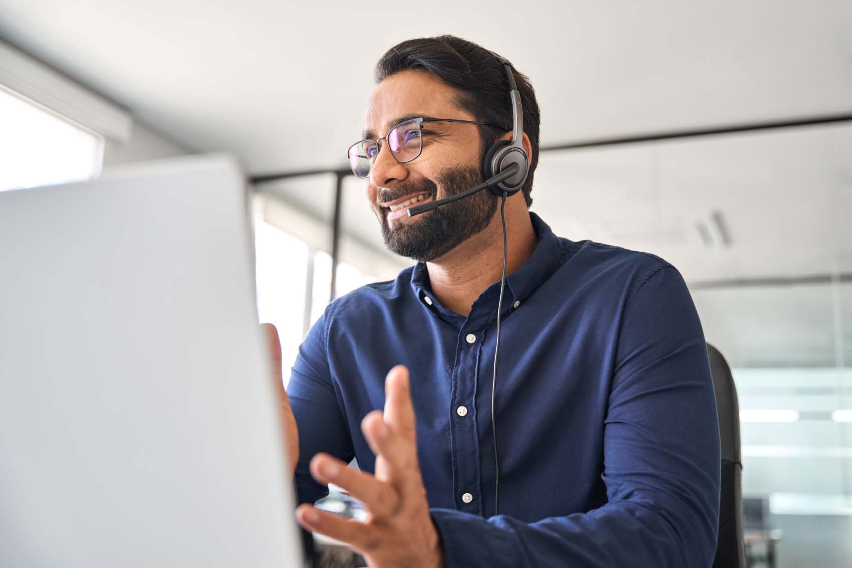 A man wearing a headset and talking to a client.
