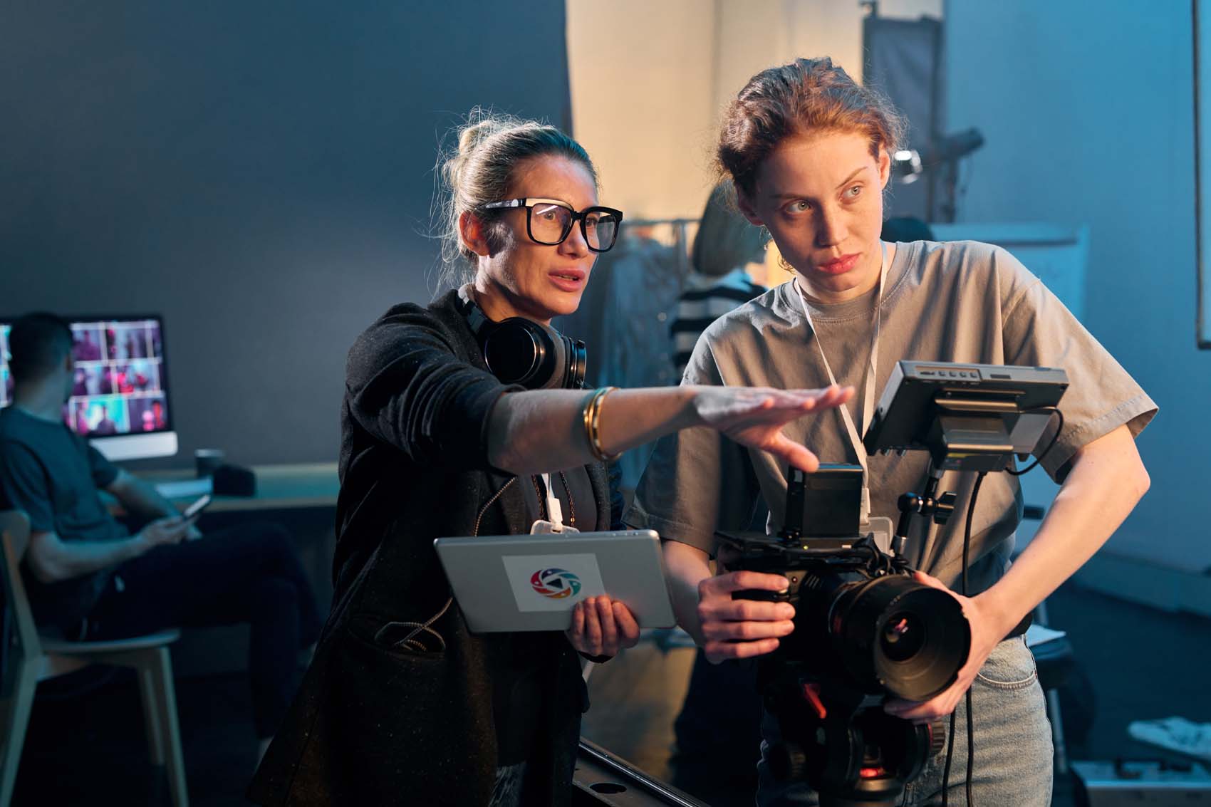 Two creative professionals standing behind a camera.